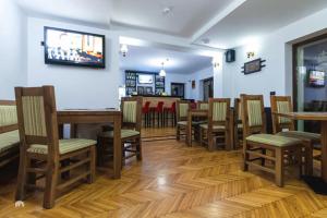 a restaurant with wooden tables and chairs and a bar at White House in Făgăraş