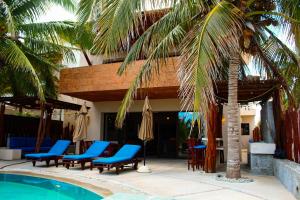 a resort with a pool and chairs and a palm tree at Egina Luxury Villa in Uaymitun