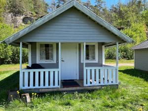 a small house with a porch on a field at Ylserod Camping in Strömstad