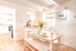 a kitchen with a table with two glasses of orange juice at Salty's Cottage in St. Agnes