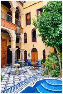 a courtyard with a fountain and a building at Riad Layalina Fes in Fez