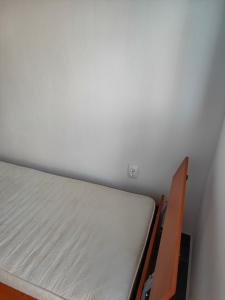 a bed in a room with a white wall at Apartment Panorama in Bar
