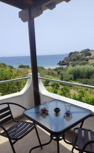 una mesa en un balcón con vistas al océano en Votsalo Beach House, en Moutsoúna