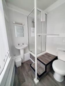 a bathroom with a shower and a toilet and a sink at Brooklyn Hotel in Blackpool +34 photos