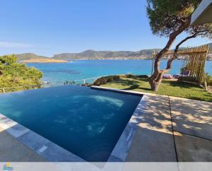 a swimming pool with a view of the water at Villa PortoMare in Porto Rafti