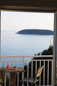 Una vista del océano desde un balcón con mesa y sillas. en Apartman Anka, en Dubrovnik