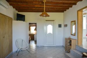 a living room with a chair and a white door at XALAKAS SUMMER HOUSE in Empourios