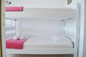 - une chambre avec 2 lits superposés et des draps roses dans l'établissement XALAKAS SUMMER HOUSE, à Empourios