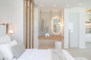 1 dormitorio con cama blanca y espejo en Porta Marina, en Naxos Chora
