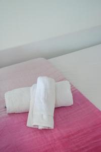 - une paire de serviettes blanches sur un lit dans l'établissement XALAKAS SUMMER HOUSE, à Empourios