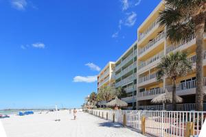 a building on the beach with palm trees and people on the beach at Ram Sea I 206 in St Pete Beach