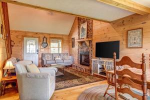 eine Blockhütte mit einem TV und einem Kamin in der Unterkunft Cabin Hideaway in Ellijay