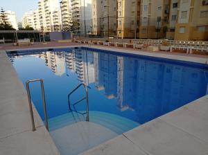 basen z niebieską wodą przed budynkami w obiekcie Bahamas II Solo Familias Serviplaya w mieście Playa de Gandia