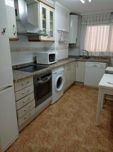 kuchnia z białymi szafkami i pralką i suszarką w obiekcie Bahamas II Solo Familias Serviplaya w mieście Playa de Gandia