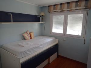 małe łóżko w pokoju z oknem w obiekcie Bahamas II Solo Familias Serviplaya w mieście Playa de Gandia +21 zdjęć