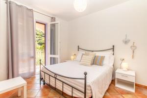 a bedroom with a bed and a balcony at Residence L'Olivastro in Castelsardo