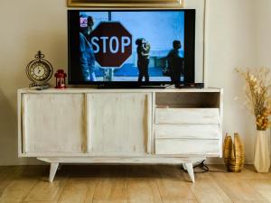 uma televisão sentada em cima de um suporte de TV com um sinal de stop em Apartment Village house em Ravno