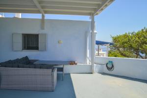 a patio with a couch and a table on a roof at XALAKAS SUMMER HOUSE in Empourios