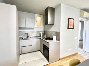 uma cozinha com armários brancos e um lavatório em ERMAN HOUSE - Naviglio Riviera del Brenta Venezia em Dolo