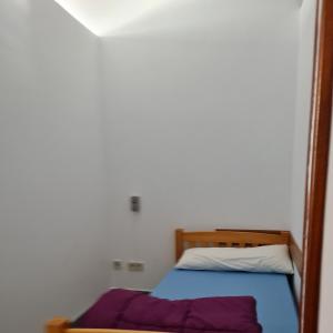 ein Schlafzimmer mit einem Bett mit einem Holzrahmen in der Unterkunft Hostel Río Eo Albergue Ribadeo in Ribadeo