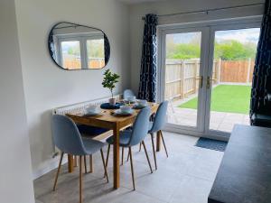 a dining room with a table and chairs and a window at Modern Family Home with Off-Road Parking in Cardiff