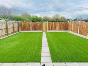 ogród z ogrodzeniem i zielonym trawnikiem w obiekcie Modern Family Home with Off-Road Parking w Cardiff