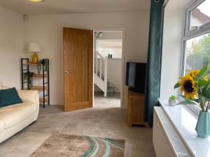 a living room with a couch and a television at Modern Family Home with Off-Road Parking in Cardiff