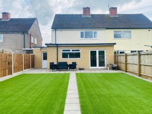 a house with a large yard with green grass at Modern Family Home with Off-Road Parking in Cardiff