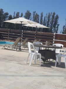 a table and chairs with umbrellas next to a pool at Sunset Villa in Nea Paphos