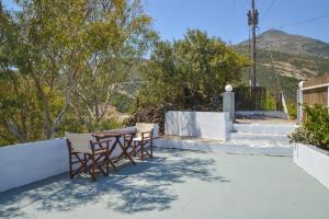 a table and chairs on a patio with mountains in the background at XALAKAS SUMMER HOUSE in Empourios
