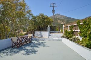 a patio with a table and chairs and mountains at XALAKAS SUMMER HOUSE in Empourios