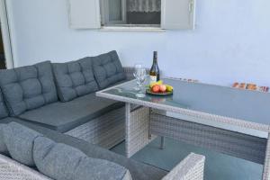 a couch and a table with a bottle of wine and fruit at XALAKAS SUMMER HOUSE in Empourios