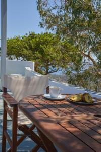 a wooden table with a cup of coffee and a plate of food at XALAKAS SUMMER HOUSE in Empourios