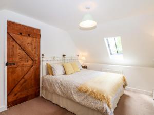 a bedroom with a bed with a wooden door at Nuthatch Cottage in Okehampton