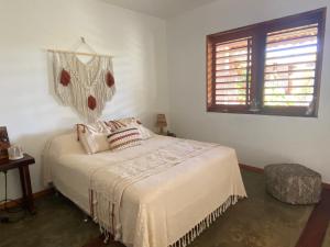 um quarto com uma cama e uma janela em Casa Tropical Taiba em Taíba