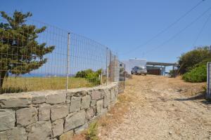 a stone retaining wall next to a fence at XALAKAS SUMMER HOUSE in Empourios