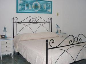 a bedroom with a bed and a picture on the wall at Le Pavoncelle Blu in Cala Gonone