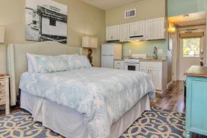 a bedroom with a large bed and a kitchen at Bungalow Beach Place 7 in Clearwater Beach