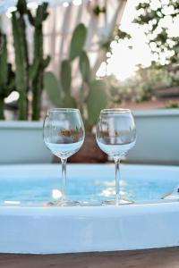due bicchieri da vino seduti sopra un tavolo di San Michele Luxury Rooms a Matera