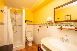 a bathroom with a sink and a toilet and a mirror at As Tapias Apartamentos in Tapia de Casariego +20 photos