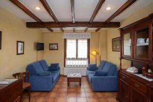 a living room with two blue chairs and a table at As Tapias Apartamentos in Tapia de Casariego