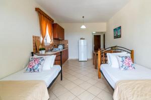a living room with two beds and a kitchen at Sunny Aprt at Klelia Cottage in Zakynthos Town