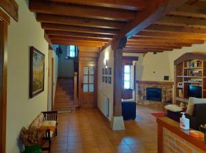 a living room with wooden ceilings and a fireplace at Casa Cordancas in Cicera