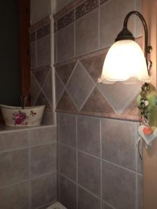 a bathroom with a light on a tiled wall at Le Pavoncelle Blu in Cala Gonone