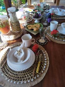 uma mesa de madeira com um conjunto de mesa com pratos de comida em Casa Tropical Taiba em Taíba