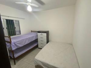 een slaapkamer met een bed, een dressoir en een raam bij Lar Doce mar in Mongaguá