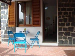 two blue chairs and a table on a patio at Le Pavoncelle Blu in Cala Gonone