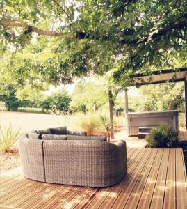 a couch sitting on top of a wooden deck at Le Domaine de Pivette Chambre climatisée et insolite avec terrasse privative in Avranches