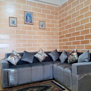 a couch in a living room with a brick wall at La casa de Wael in Ifrane
