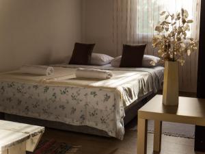 a bedroom with two beds and a vase with flowers at Apartment Village house in Ravno